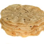 indian food stack of spiced poppadoms isolated on a white background