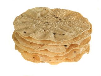 indian food stack of spiced poppadoms isolated on a white background