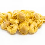 Italian traditional tortellini pasta isolated on white background.. The shape needed for a mushroom duxelle filled tortellini.