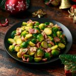 Christmas Brussel Sprouts and Bacon with decoration, gifts, green tree branch on wooden rustic table.