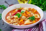 Minestrone, Italian vegetable soup with pasta on table. Vegan food.