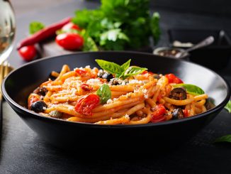 Spaghetti alla puttanesca - italian pasta dish with tomatoes, black olives, capers, anchovies and basil