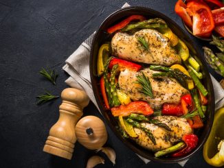 Baked chicken breasts (fillet) with vegetables. Healthy food, keto diet, one pot dish. Top view at dark table.