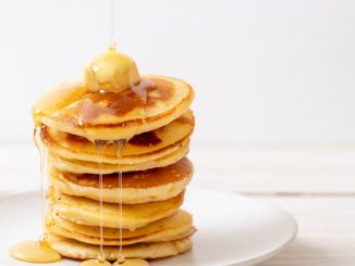buttermilk pancakes stacked with butter and honey topping