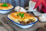 Steak and mushroom pie on rustic wooden background