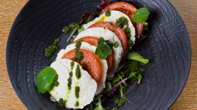 Caprese salad is a simple Italian salad, made of sliced fresh mozzarella, tomatoes, and sweet basil, seasoned with salt and olive oil, occasionally paired with arugula. Insalata Caprese