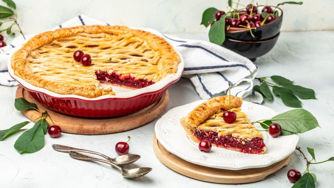 Delicious Homemade Cherry Pie, Flaky Crust, piece on a plate and the whole homemade cherry pie, top view,