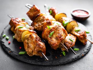 Grilled meat skewers, shish kebabs on black background