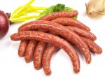 making sausages: sausages on a white background with a red onion in partial view.