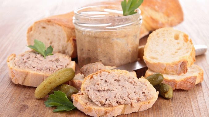 Ardennes pate on bread on a wooden table.