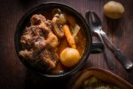 Potjiekos South African oxtail stew with baby gold potatoes carrots and button mushrooms.
