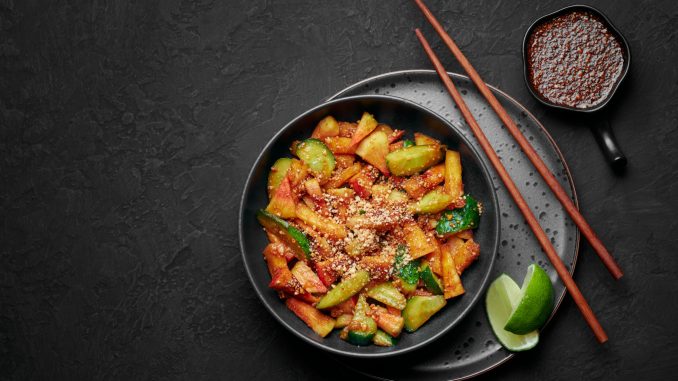 Penang Rojak in black bowl on dark slate table top. Malaysian or indonesian cuisine fruits and vegetables salad dish. Asian Food. Korean traditional food Stir-fried sweet potato with sesame seeds. Top view. Copy space