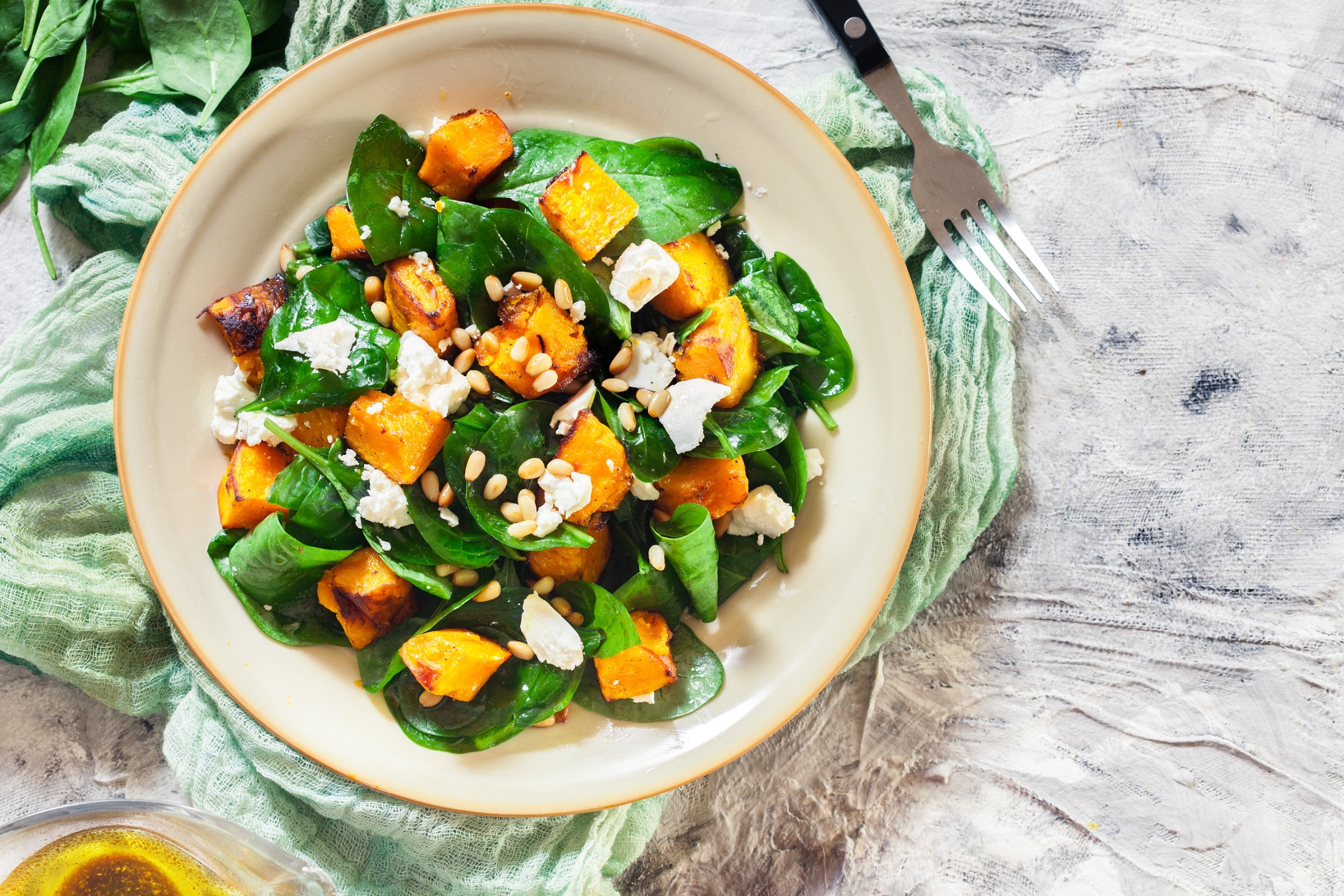 Roasted pumpkin salad with spinach, feta and pine nuts. Autumn dish