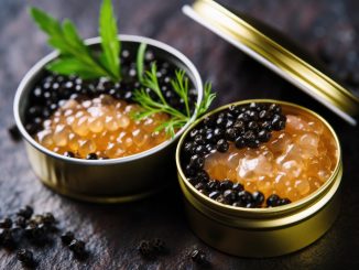 Black and red caviar in a tin can on a dark background