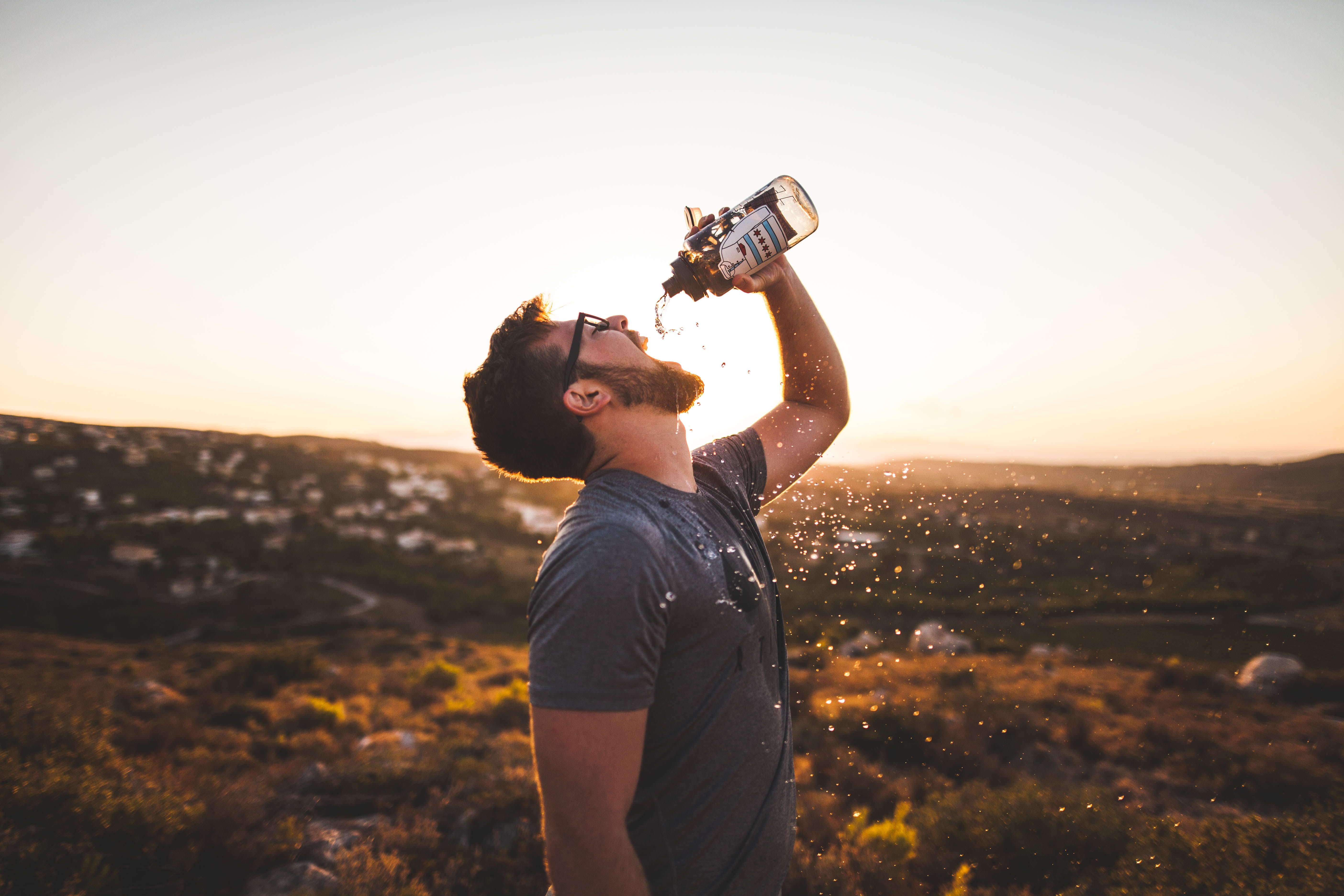 man drinking water from a smart water bottle
