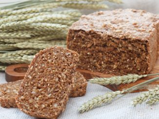 sprouted grain bread on a table with wheat ears.