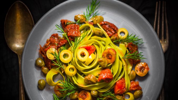 Tagliatelle pasta with tomatoes, sun-dried tomatoes, olives and dill