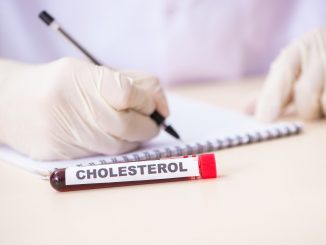 Tube of blood with cholesterol written on vial.
