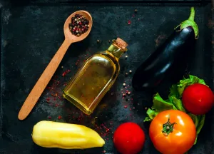 wooden spoon with spices and fresh vegetables for healthy cooking on background of old rusty metals, top view,copy space, closeup. Diet, pure food or the concept of vegetarian food.