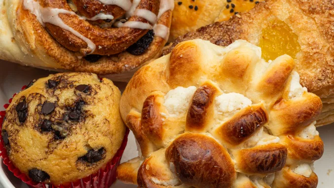 Close-up of a white plate with different freshly baked desserts, cinnamon roll, cupcake, and a sweet pastry. Use fat replacers. baking powder, leavening agents