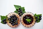 Ripe, sweet black currant on white background. Blackcurrant jam