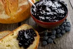 blueberry jam with bread on wood background