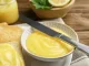 Delicious lemon curd and fresh toasts on wooden table, closeup