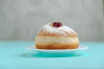 Tradition Jewish holiday sweets, donut sufganiyot with sugar powder and jam.