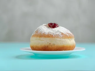 Tradition Jewish holiday sweets, donut sufganiyot with sugar powder and jam.