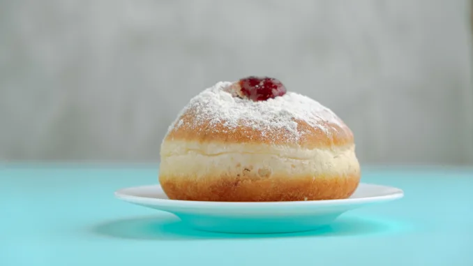 Tradition Jewish holiday sweets, donut sufganiyot with sugar powder and jam.