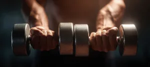 Close-up of hands gripping shiny dumbbells, captured with cinematic lighting. The image emphasizes health, strength, and a positive, realistic tone