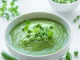 Fresh green pea soup bowl on gray concrete background