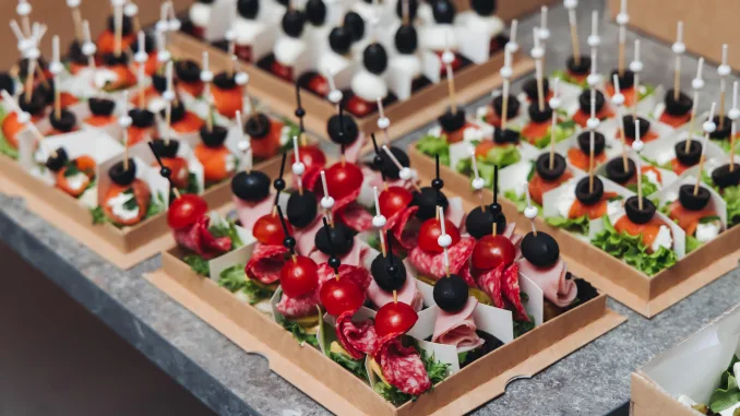 Catering table, beautifully decorated banquet with variety different food snacks appetizers on christmas corporate birthday party event or wedding celebration, canape, salad, delicatessen setting. Hors d'oevres