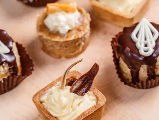 Assorted different mini cakes or petit fours with cream and chocolate