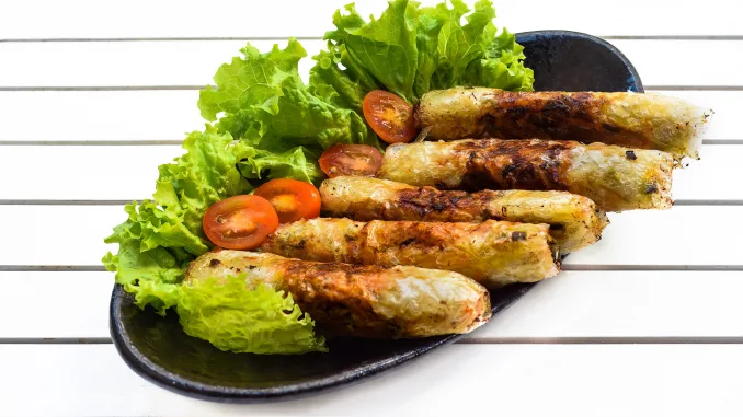 Traditional fried vietnamese spring rolls with pork, rice paper on black background side view